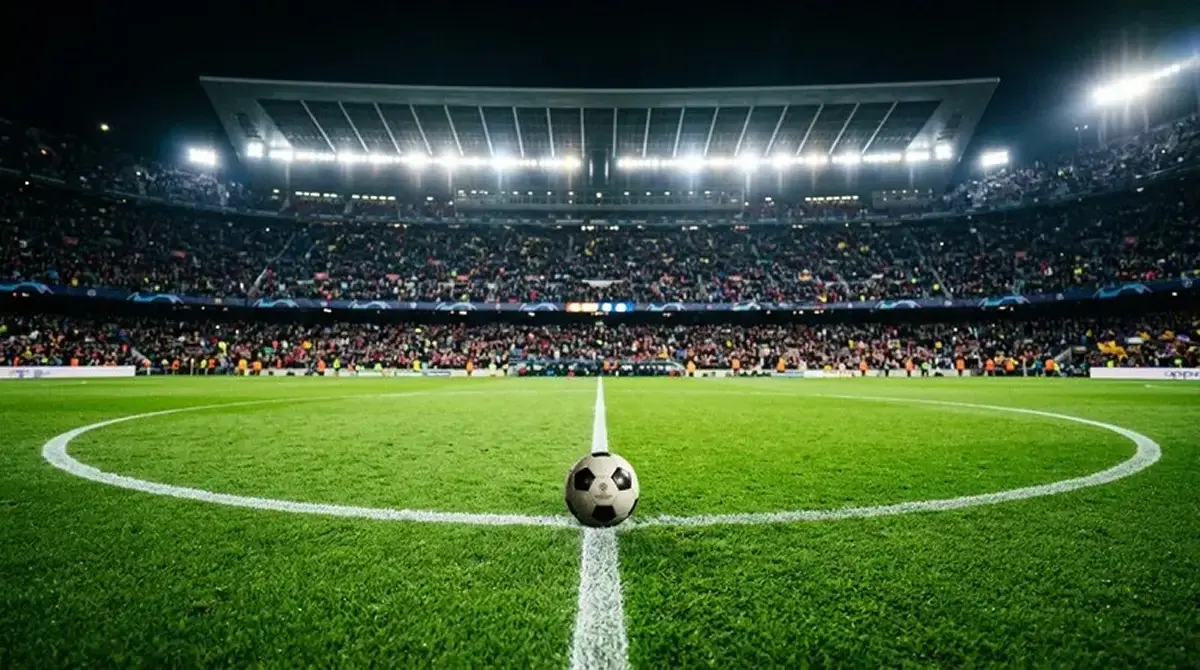 Jalkapallo keskiympyrässä valaistulla MM-stadionilla juuri ennen ottelun alkua